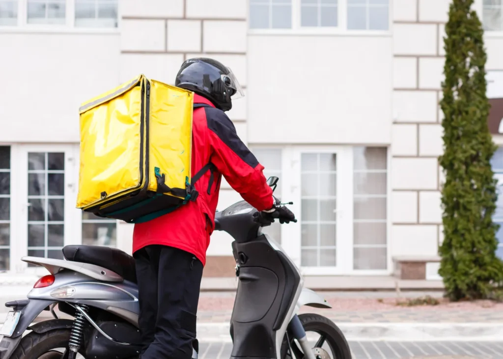 Restaurant food delivery man with a food delivery bag and a scooter